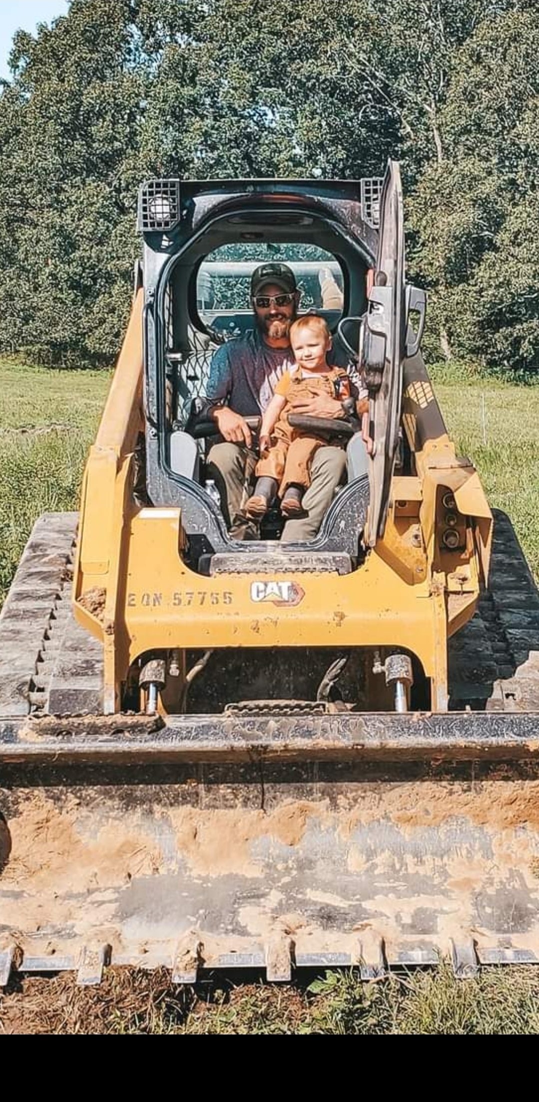 Jacob teaching his child to run a CAT loader